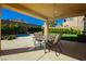A covered patio has an outdoor dining table and views of a manicured yard and a sparkling pool at 29 Blue Valley Dr, Henderson, NV 89002