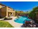 An inviting backyard boasts a sparkling pool, stone accents, a spa, lounge furniture, and beautiful landscaping at 29 Blue Valley Dr, Henderson, NV 89002