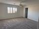 Spacious bedroom with large window, ceiling fan, plush carpeting, and plenty of natural light at 311 Glenoaks St, Pahrump, NV 89048