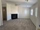 Open living room with modern fireplace, neutral carpet, and bright shuttered windows at 311 Glenoaks St, Pahrump, NV 89048