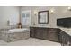Elegant bathroom featuring granite counters, dual sinks, a soaking tub, and modern fixtures at 3155 Dalmazia Ave, Henderson, NV 89044