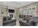 Cozy living room with a fireplace, TV, stylish furniture, and ample natural light from shuttered windows at 3155 Dalmazia Ave, Henderson, NV 89044