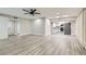 Open living space featuring modern gray wood floors and bright lighting with kitchen area view at 3310 Heritage Pl, Las Vegas, NV 89121
