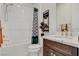 Well-lit bathroom featuring a shower-tub combination, white tiled walls, and a stylish marble countertop sink at 350 Gandara St, Las Vegas, NV 89138