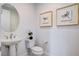 Clean powder room featuring a pedestal sink, modern fixtures, and minimalist artwork at 350 Gandara St, Las Vegas, NV 89138