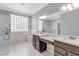 Bathroom with double sink vanity, glass block window, and a glass shower with marble at 4227 Pacifico Ln, Las Vegas, NV 89135