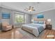 Staged bedroom features wood floors, a ceiling fan, a bay window, and calming decor at 4227 Pacifico Ln, Las Vegas, NV 89135