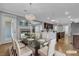Staged dining room with glass table, adjacent to kitchen and living area at 4227 Pacifico Ln, Las Vegas, NV 89135