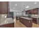 Bright kitchen with a skylight, dark cabinets, stainless steel appliances, and granite countertops at 4227 Pacifico Ln, Las Vegas, NV 89135
