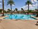 Large, inviting swimming pool surrounded by palm trees and comfortable lounge chairs at 4227 Pacifico Ln, Las Vegas, NV 89135