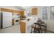 Efficient kitchen layout with wooden cabinets, breakfast bar, and white appliances at 4336 Desert Dancer Way, Las Vegas, NV 89147