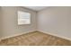This bedroom features neutral walls, tan carpet, and a window for natural light at 4533 Diamond Head Dr, Las Vegas, NV 89110
