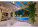 Stylish backyard with a covered patio, pool, and ambient lighting, perfect for evening relaxation and entertainment at 5125 Turnberry Ln, Las Vegas, NV 89113