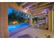 Inviting covered patio overlooking a sparkling pool and lush landscaping, perfect for relaxation and entertainment at twilight at 5125 Turnberry Ln, Las Vegas, NV 89113