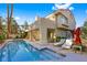 Beautifully landscaped backyard with a sparkling pool, lounge chairs, and an umbrella, perfect for relaxation and entertaining at 5125 Turnberry Ln, Las Vegas, NV 89113