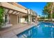 Relaxing backyard pool with covered patio, lounge seating, and lush greenery, ideal for enjoying sunny days at 5125 Turnberry Ln, Las Vegas, NV 89113