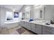 Bright bathroom featuring a soaking tub, dual sinks, and modern fixtures for a spa-like experience at 5125 Turnberry Ln, Las Vegas, NV 89113