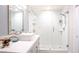 Bright bathroom with frameless glass shower, pebble floor, and white tiled walls at 5125 Turnberry Ln, Las Vegas, NV 89113