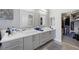 Bathroom featuring dual sinks, modern cabinets, and a glimpse into the walk-in closet at 5125 Turnberry Ln, Las Vegas, NV 89113