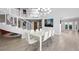 Bright, open-concept dining area with sleek white furnishings and a modern staircase, perfect for entertaining at 5125 Turnberry Ln, Las Vegas, NV 89113