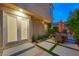 Exterior of house featuring a set of double doors with a patio, lawn, and landscaping at 5125 Turnberry Ln, Las Vegas, NV 89113