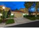 Charming two-story home with a well-maintained lawn, driveway, and two-car garage at dusk at 5125 Turnberry Ln, Las Vegas, NV 89113