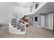 Elegant foyer featuring a curved staircase, modern railings, and stylish artwork at 5125 Turnberry Ln, Las Vegas, NV 89113