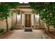Inviting front entrance with a solid wood door, sidelights, and sconces, framed by lush greenery at 5125 Turnberry Ln, Las Vegas, NV 89113