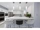 Bright kitchen features stainless steel appliances, white cabinets, pendant lighting, and a breakfast bar with seating at 5125 Turnberry Ln, Las Vegas, NV 89113