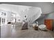 Spacious living room with a curved staircase, fireplace, and dining area at 5125 Turnberry Ln, Las Vegas, NV 89113