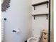 Bright bathroom features a toilet, floating shelves, decorative mirror, and towel rack at 5400 Tassara Way # 106, Las Vegas, NV 89108