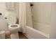 Bright bathroom with a toilet next to a bathtub with shower at 5400 Tassara Way # 106, Las Vegas, NV 89108