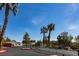 Gated entrance to the community with tall palm trees and blue skies in the background at 5400 Tassara Way # 106, Las Vegas, NV 89108