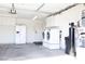 Clean garage with laundry machines, refrigerator, water heater, and ample room at 5400 Tassara Way # 106, Las Vegas, NV 89108