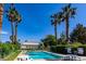 Community pool with lounge furniture, tables, and multiple palm trees in the background at 5400 Tassara Way # 106, Las Vegas, NV 89108