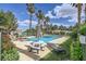 Community pool with a picnic table, lounge chair, palm trees, and well manicured lawn at 5400 Tassara Way # 106, Las Vegas, NV 89108