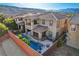 Stunning aerial view of the home with a backyard pool, patio, lush landscaping, and mountain views at 5434 Fawn Chase Way, Las Vegas, NV 89135