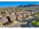 Neighborhood aerial view with houses, manicured lawns, paved roads, and distant mountain views at 5434 Fawn Chase Way, Las Vegas, NV 89135