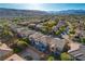 Stunning aerial view of a suburban neighborhood with lush green trees and mountain backdrop at 5434 Fawn Chase Way, Las Vegas, NV 89135