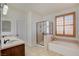 Bright bathroom with a double vanity, walk-in shower, and separate bathtub, offering a spa-like experience at 5434 Fawn Chase Way, Las Vegas, NV 89135
