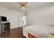 Neutral bedroom with dark wood floor, white walls, ceiling fan, door leading to a hall at 5434 Fawn Chase Way, Las Vegas, NV 89135