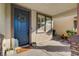 Inviting front porch with a dark blue door, welcome mat, and charming potted flowers at 5434 Fawn Chase Way, Las Vegas, NV 89135