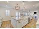 Open concept kitchen features a center island with a farmhouse sink and modern pendant lighting at 5434 Fawn Chase Way, Las Vegas, NV 89135