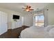 This is a primary bedroom with a balcony, ceiling fan, and television set on a white dresser at 5434 Fawn Chase Way, Las Vegas, NV 89135