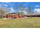 Community playground with a grass area, trees, and a playground with a slide and swing sets at 5434 Fawn Chase Way, Las Vegas, NV 89135
