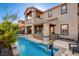 Gorgeous backyard pool and patio with a basketball hoop, outdoor kitchen, and covered patio with seating at 5434 Fawn Chase Way, Las Vegas, NV 89135