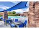 Community pool area with tables, chairs, shade, and a beautiful stone structure for residents to enjoy at 5434 Fawn Chase Way, Las Vegas, NV 89135