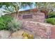 Decorative stone community entrance sign with 'Ladera' prominently displayed, enhanced by lush desert landscaping at 5434 Fawn Chase Way, Las Vegas, NV 89135