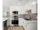 Stylish kitchen featuring white cabinets, stainless steel appliances, and modern backsplash at 5817 Glen Eagles Ln, Las Vegas, NV 89108