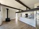Spacious living room with hardwood floors, beamed ceilings, a cozy fireplace, and an open-concept kitchen at 6261 Rassler Ave, Las Vegas, NV 89107